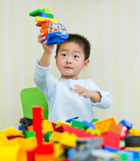Young boy playing with Lego blocks
