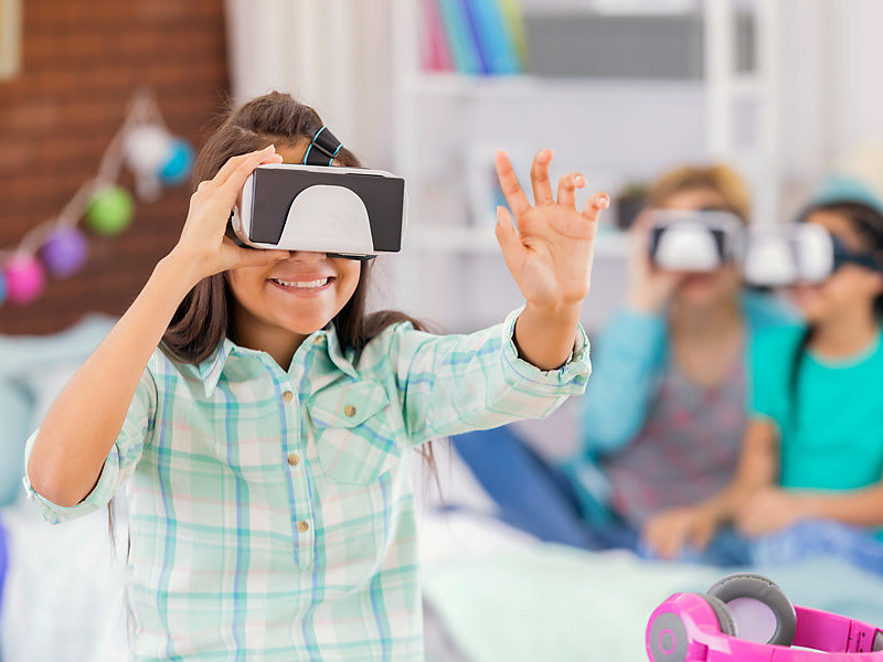 Girls using virtual reality goggles during a party
