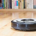 Used robotic vacuum cleaner closeup. All potential trademarks and control buttons are removed.