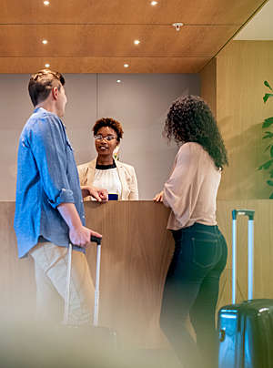 Couple talking to a female receptionist.