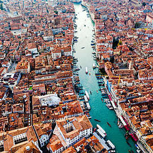 Red rooftops of an old city centre with river running through.