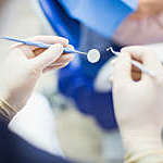 Plan POV d'un homme dentiste avec des outils dentaires à la main. Dentiste au travail avec des gants chirurgicaux et des outils à la main.