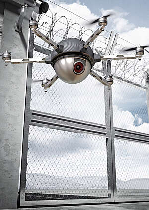 Spherical camera drone patrolling in front of a border security gate topped with barbed wire.