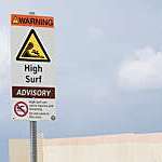 High surf wave warning sign the beach.