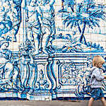 Boy walking in front of cloisters of Porto cathedral, Portugal.