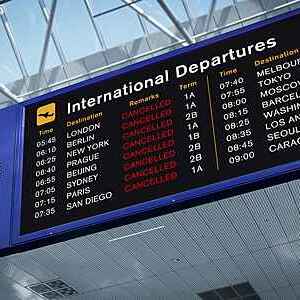 Airport international departures board with all flights marked as cancelled in red letters.